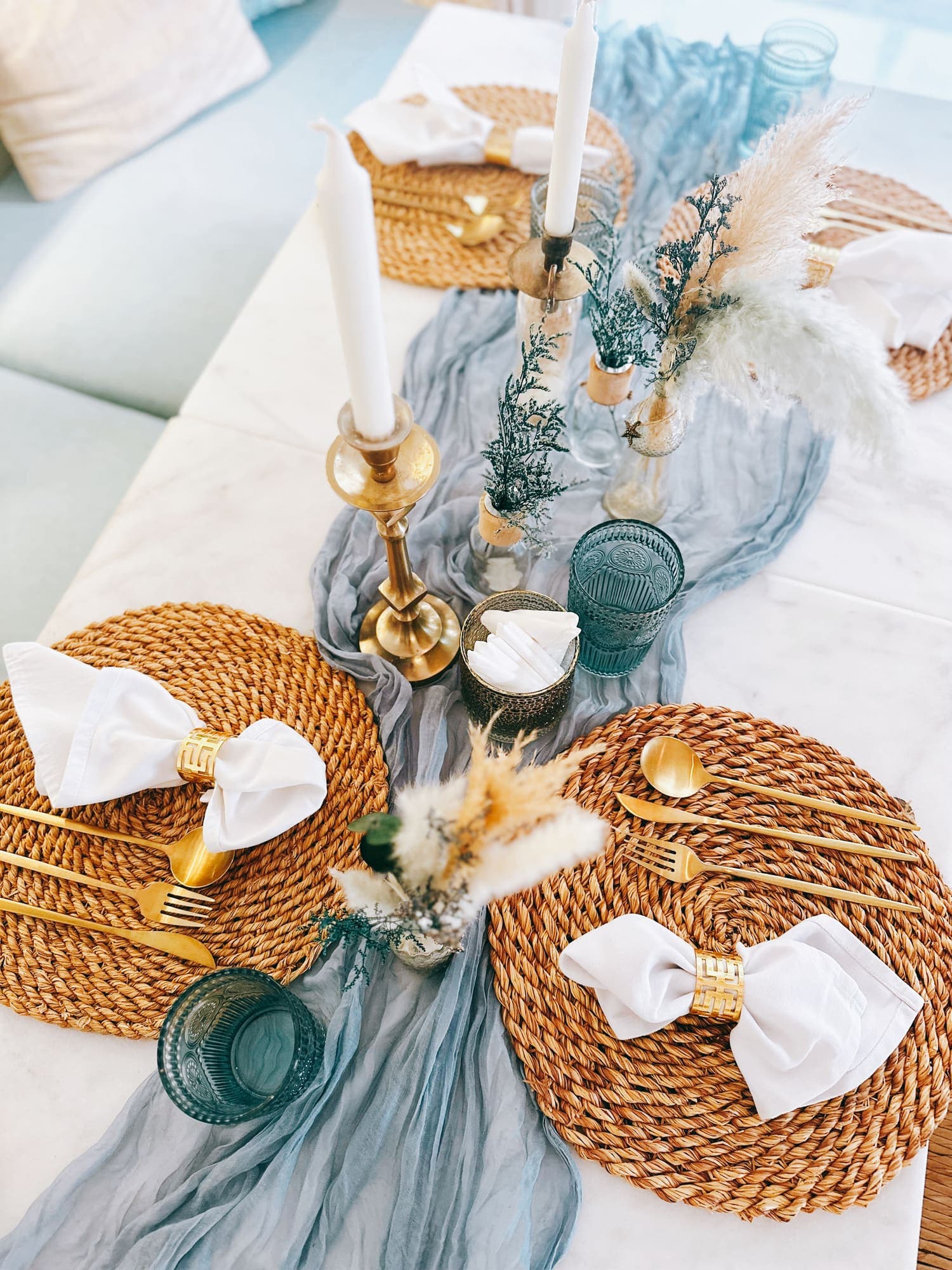 Table setting from above: woven placemat, gold cutlery, candle