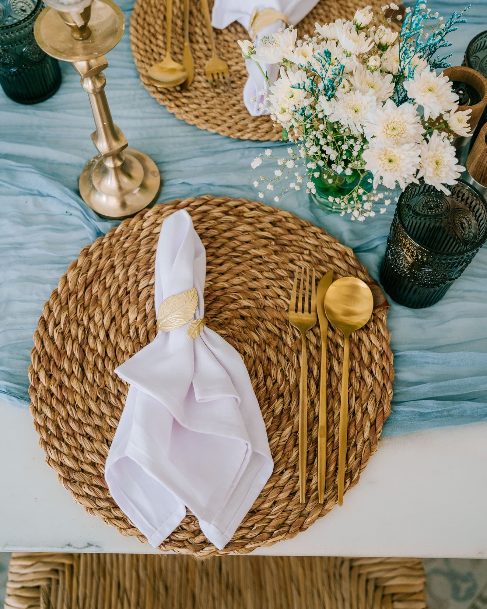 Place setting with white flowers and a brass candlestick